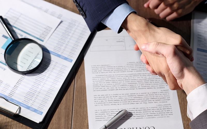 A handshake in agreement on a payment processing contract.