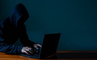 Man wearing a black hoodie representing a hacker.
