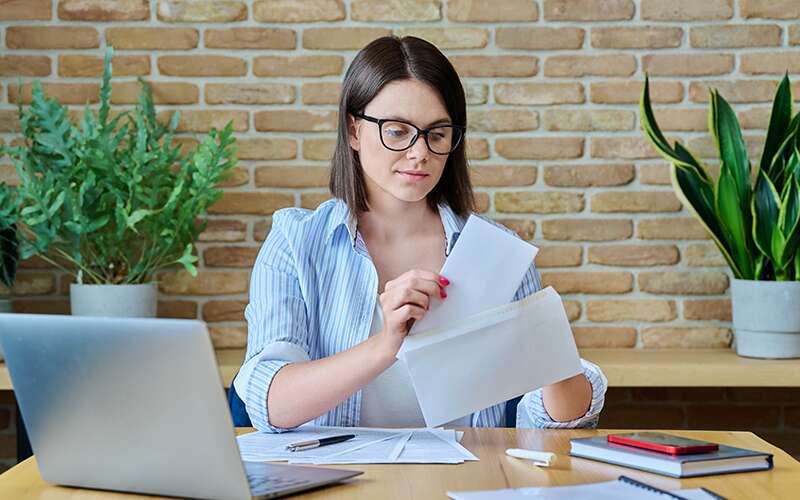 A merchant places a letter in a cover letter in an envelope.