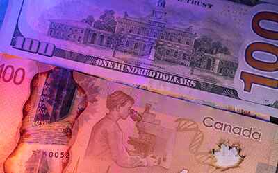 A US and Canadian hundred Dollar note representing Multi-currency transactions.