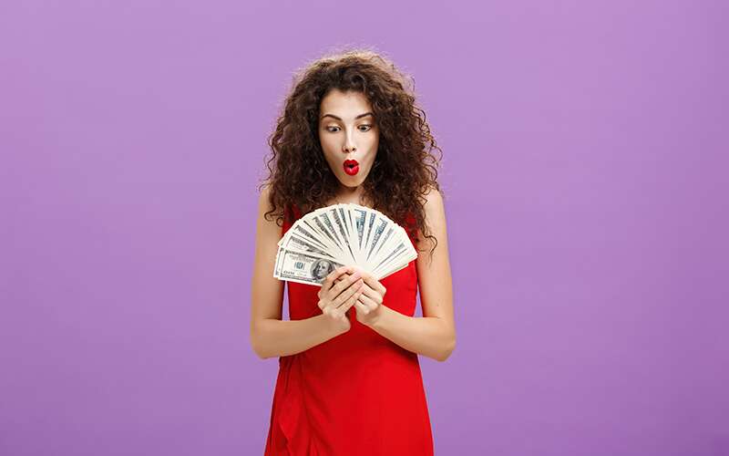 Woman holding cash.